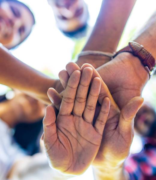 Diverse of big group of peoples hands together outdoors .