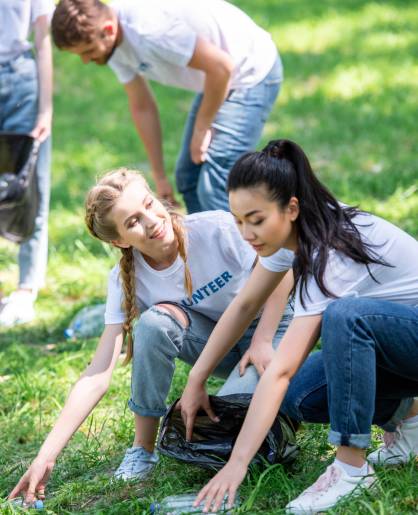 young happy volunteers cleaning green lawn